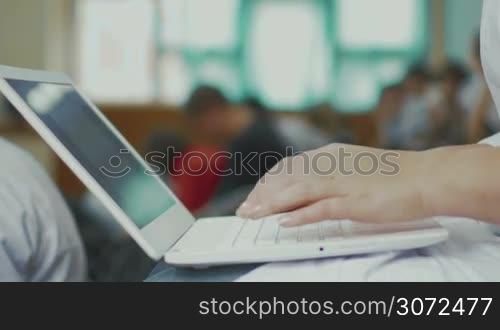 Close-up shot of woman hands typing on laptop during the lecture at the medical university or conference. Easy study with wireless device
