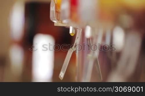 Close-up shot of womans hands pouring orange juice into the glass using the machine in a cafe
