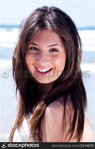 Close up shot of young beautiful woman looking at you over blue sea background