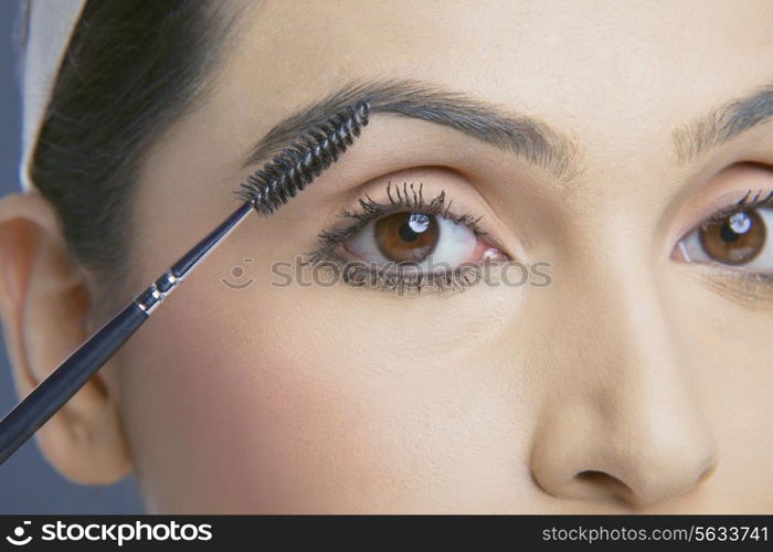 Close-up shot of young woman with an eyebrow tinting applicator