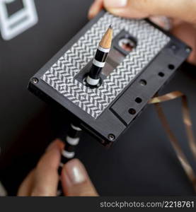 close up shot person repairing cassette tape with pencil