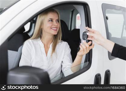 close up shot with smiley woman receiving car key