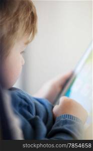 Close up side view of young boy using smart tablet