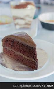 close up slice of chocolate fudge cake on white dish. chocolate cake