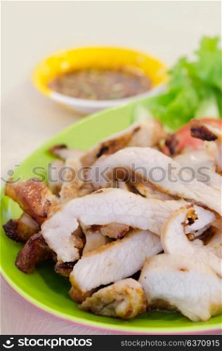 close up sliced roasted pork served with vegetable and chili sauce