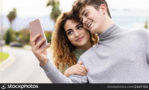 close up smiley couple taking selfie outdoors