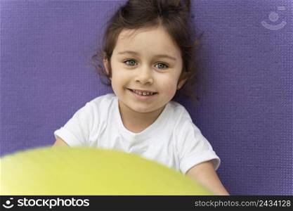 close up smiley kid holding gym ball