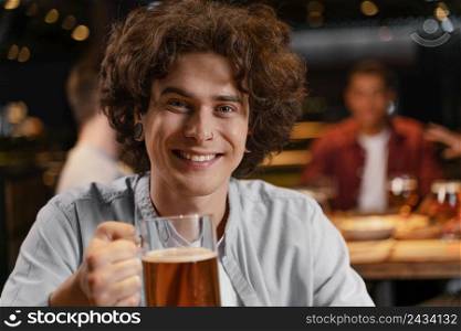 close up smiley man holding beer mug pub
