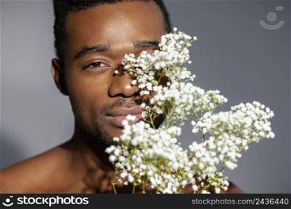 close up smiley man posing with flowers