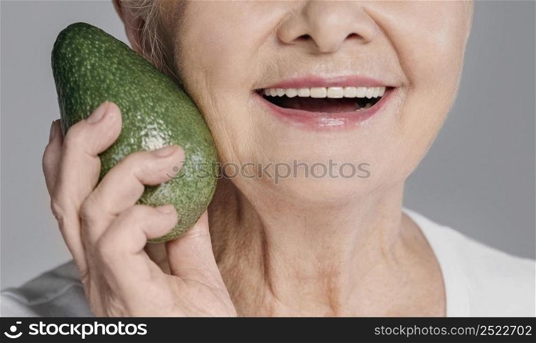 close up smiley woman holding avocado