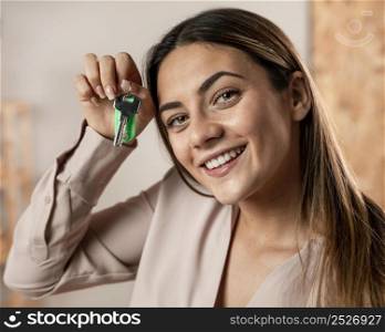 close up smiley woman holding keys
