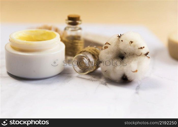 close up spa cream bottle with cotton flower