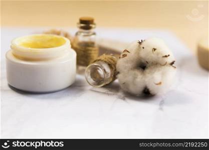 close up spa cream bottle with cotton flower