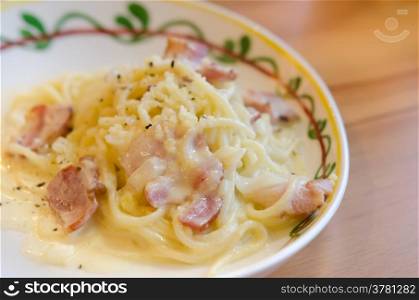 close up spaghetti carbonara with bacon and cheese on dish over wooden table. Spaghetti Carbonara