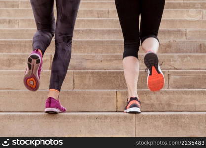 close up sportswomen climbing stairs