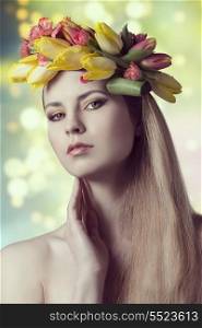 close-up spring portrait of sexy blonde girl, with long smooth hair, floral garland and colorful make-up. Looking in camera