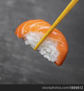 close up sticks holding tasty sushi 2. Resolution and high quality beautiful photo. close up sticks holding tasty sushi 2. High quality beautiful photo concept