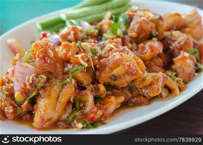 close up stir fried chicken with sweet sauce , chili and mix vegetable , served with fresh vegetable on dish