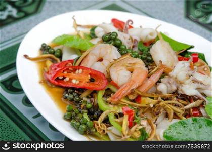close up stir fried seafood with mix herbal on white dish