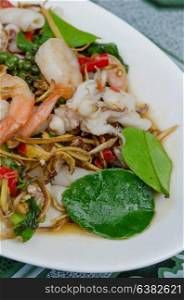 close up stir fried squid and shrimp with mix herbal on dish