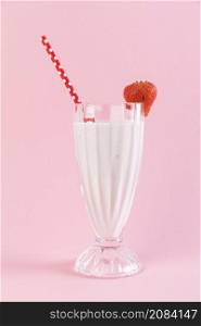 close up strawberry milkshake glass with pink background