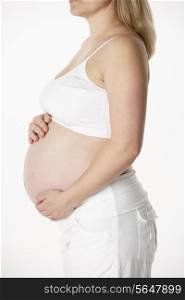Close Up Studio Portrait Of 6 months Pregnant Woman Wearing White