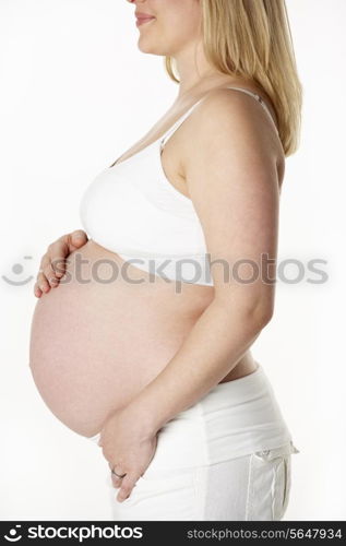 Close Up Studio Portrait Of 7 months Pregnant Woman Wearing White