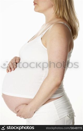 Close Up Studio Portrait Of 8 Months Pregnant Woman Wearing White