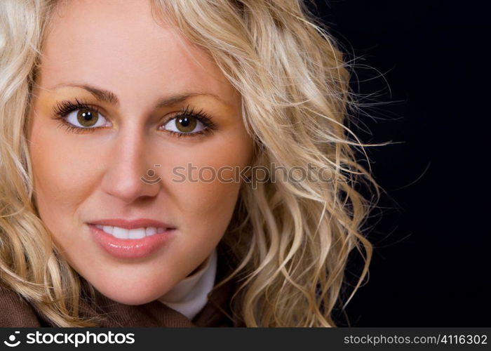 Close up studio portrait of a beautiful young blond model with blond hair and deep brown eyes.