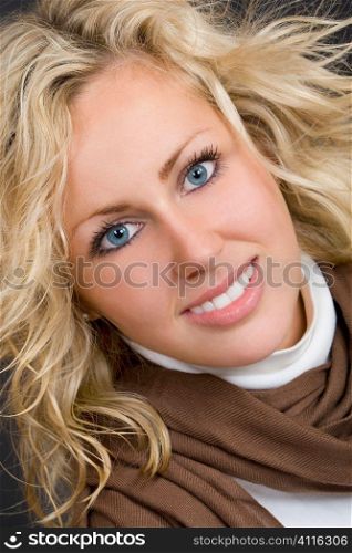 Close up studio portrait of a beautiful young blond model with blond hair and bright blue eyes.