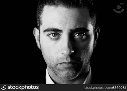 Close up studio portrait of a serious man on black background