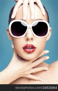close up studio portrait of young beautiful woman wearing white sunglasses