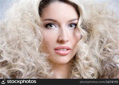 close-up studio portrait of young caucasian woman with curly hair