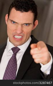 Close up studio shot of a smartly dressed man reacting angrily to camera