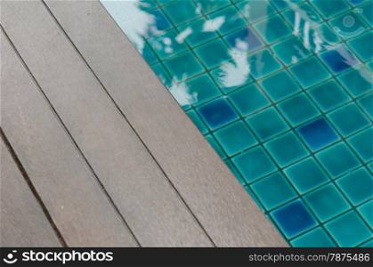 close up swimming pool with wood flooring stripes. water and wooden