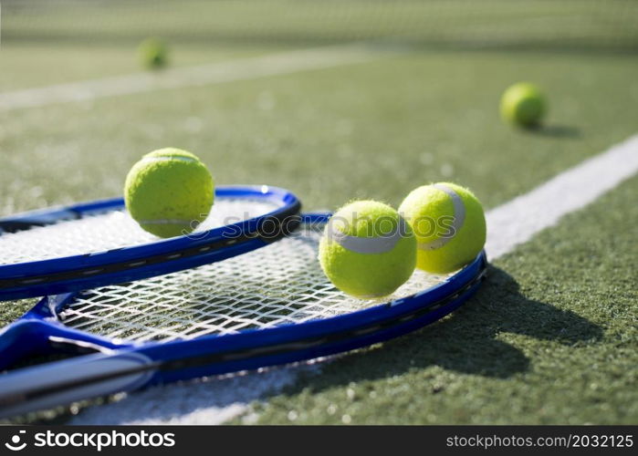 close up tennis rackets balls ground