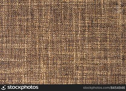 Close-up texture of natural brown coarse weave fabric or cloth. Fabric texture of natural cotton or linen textile material. Blue canvas background. Decorative fabric for upholstery, furniture, walls. Close up texture of brown coarse weave upholstery fabric. Decorative textile background