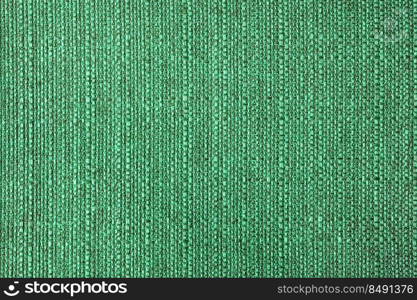 Close-up texture of natural green coarse weave fabric or cloth. Fabric texture of natural cotton or linen textile material. Blue canvas background. Decorative fabric for upholstery, furniture, walls. Close up texture of green coarse weave upholstery fabric. Decorative textile background