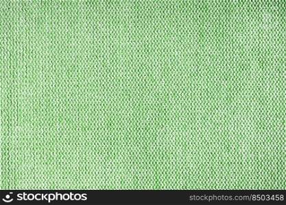Close-up texture of natural green coarse weave fabric or cloth. Fabric texture of natural cotton or linen textile material. Blue canvas background. Decorative fabric for upholstery, furniture, walls. Close up texture of green coarse weave upholstery fabric. Decorative textile background