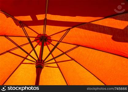 Close-up the structure of the orange beach umbrella made of wooden for protected sunlight.