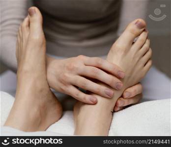 close up therapist massaging foot
