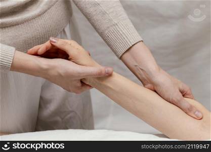 close up therapist massaging patient s arm