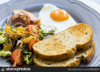 close up toast fried eggs salad bacon served ceramic plate. High resolution photo. close up toast fried eggs salad bacon served ceramic plate. High quality photo