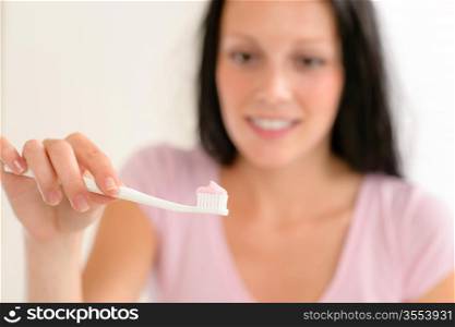 Close-up toothbrush with toothpaste with background woman before teeth brushing