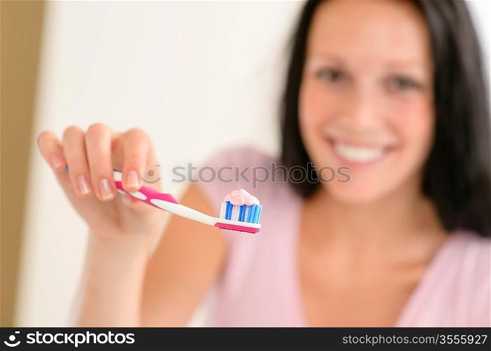 Close-up toothbrush with toothpaste with background woman before teeth hygiene