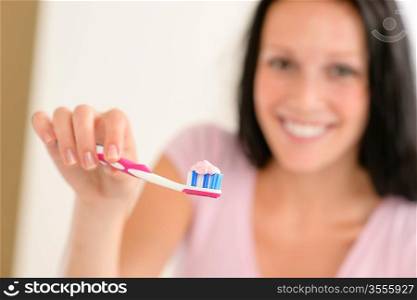 Close-up toothbrush with toothpaste with background woman before teeth hygiene