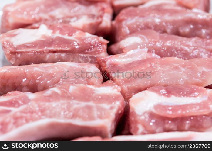 Close up top view pack pieces raw meat of pork loin on bone, fresh red pork with white fat of pork rib, Cut into pieces and put them in a row. Close up pack raw pork rib