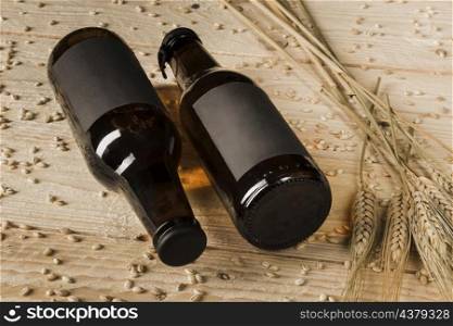 close up two beer bottles ears wheat wooden background