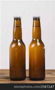 close up two beer bottles wooden surface
