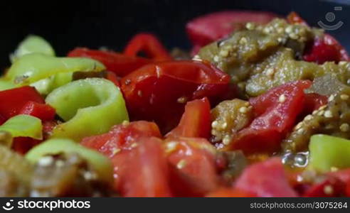 Close up vegetable ragout being quenched in saucepan with red and green paprika zucchini and tomato